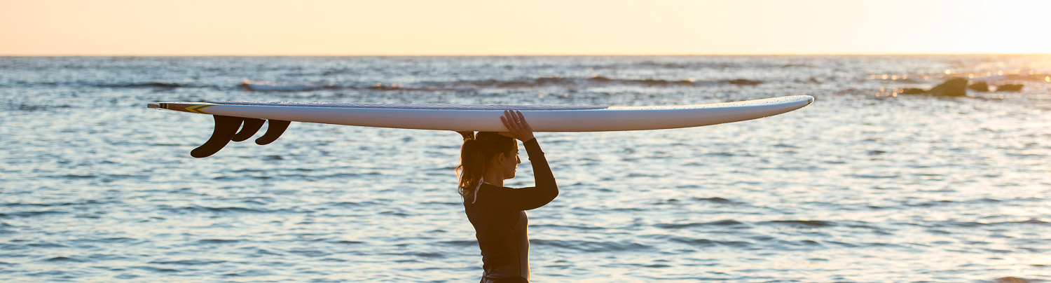 stand up paddle board being carried along the beach