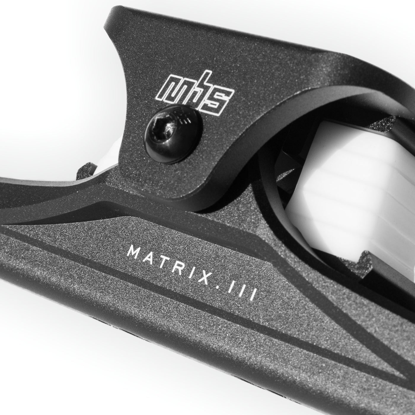Close-up of MBS Matrix III CNC truck's wide top truck and adjustable shock block positions.