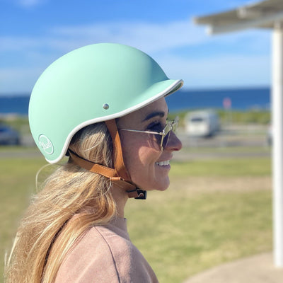 Side view of a female wearing the Mint Heritage Helmet by Thousand