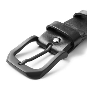 A side angle image focusing on the matte black anodized metal buckle and the nine-hole design, emphasizing the belt's modern, minimalist style.

