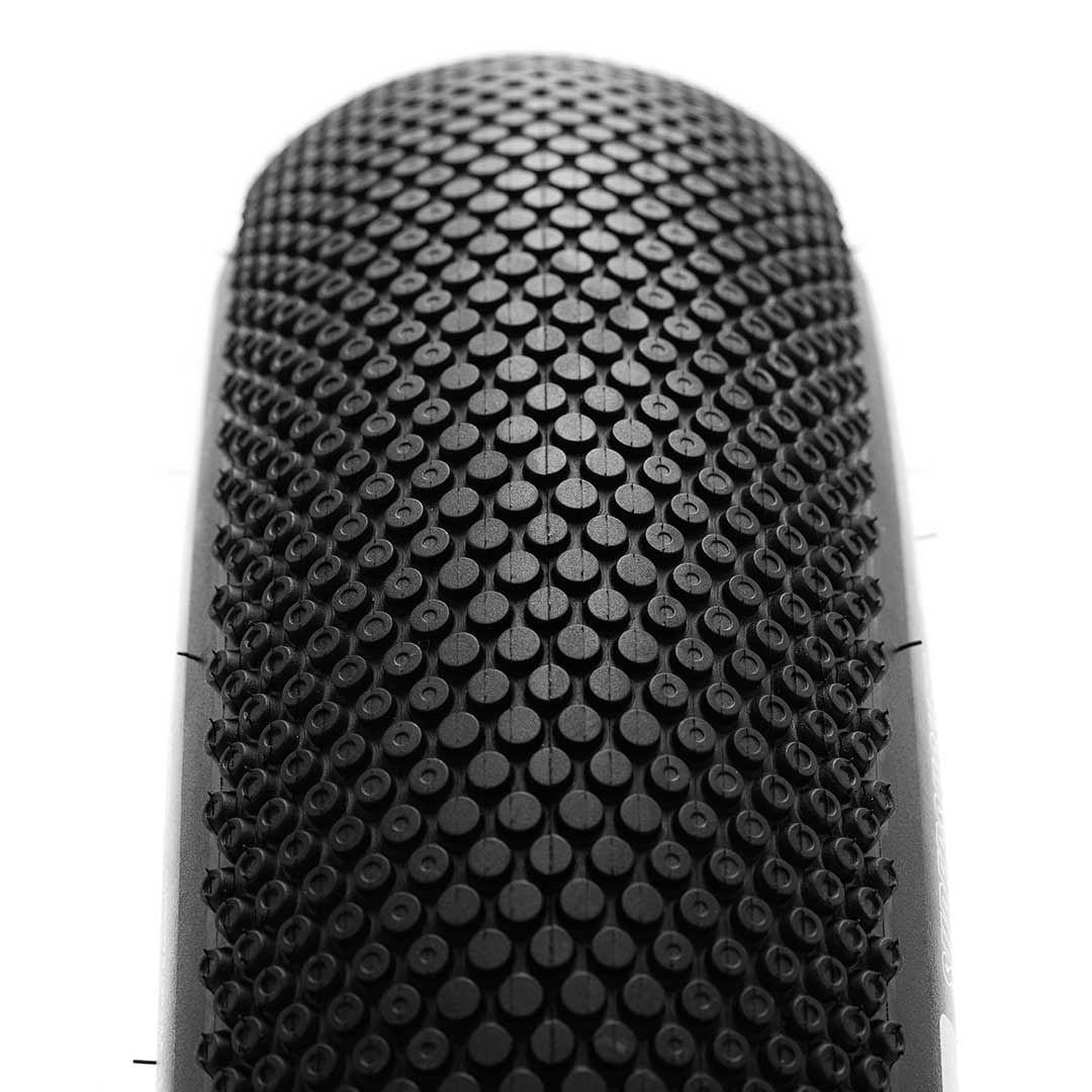 Close-up of the MAXXIS SuperSucker street tire showcasing its micro-knurled surface texture and patented all-weather tread for enhanced grip and durability.