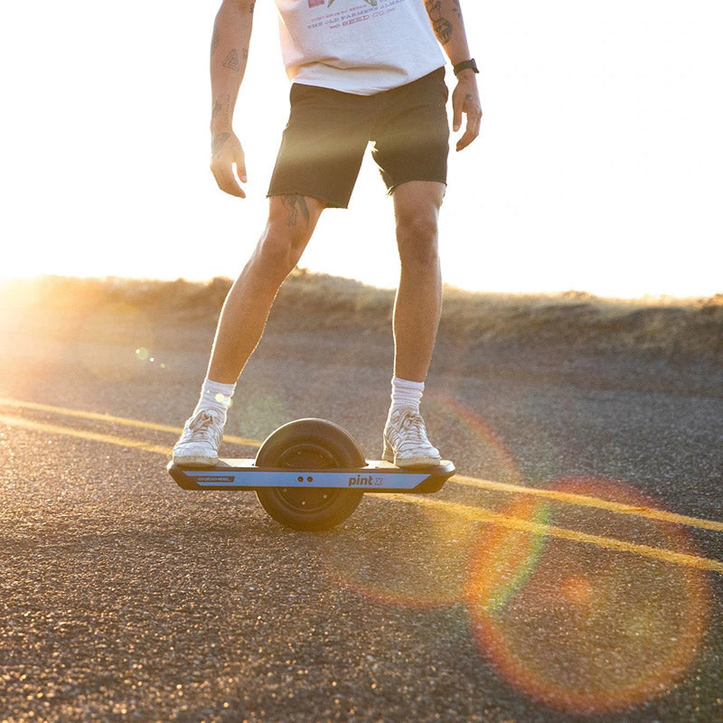 Riding a Pint X on a road in the sun for Onewheel